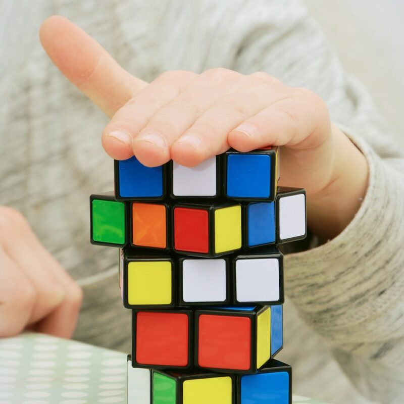 A man placing his hand in rubik's cube