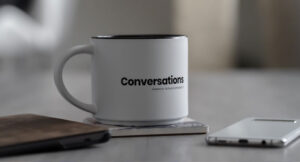 White coffee cup with writing that says "conversations"